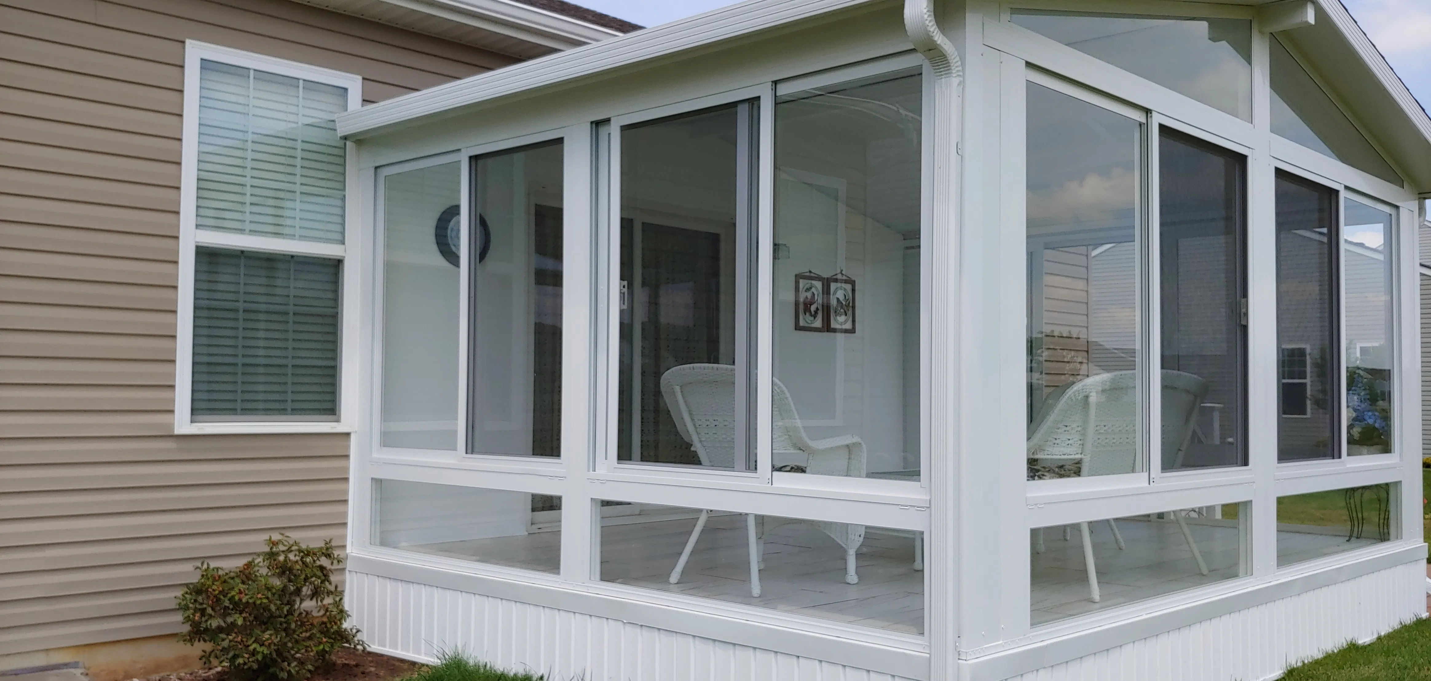 Sunroom with wicker seating visible through the glass
