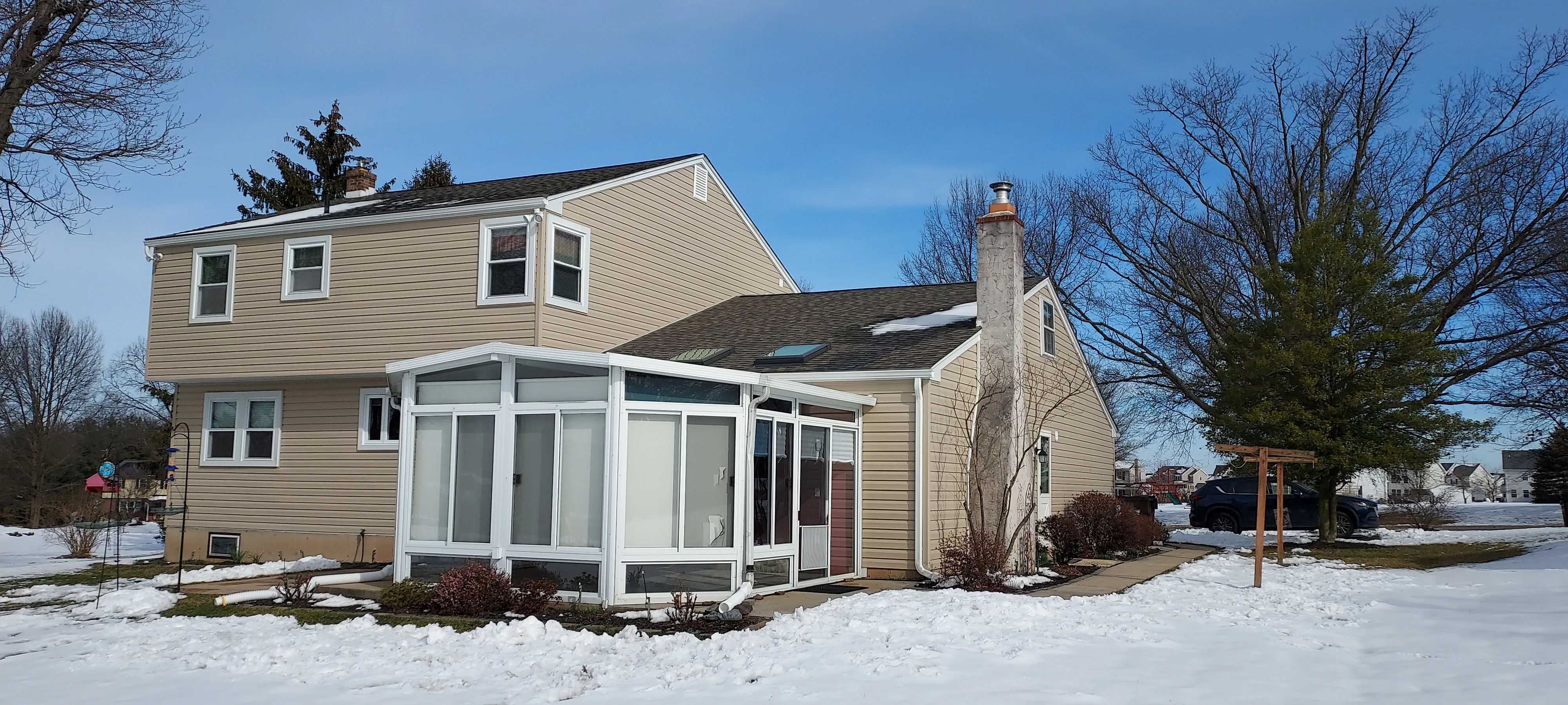 Sunroom on a cape-style home in winter snow